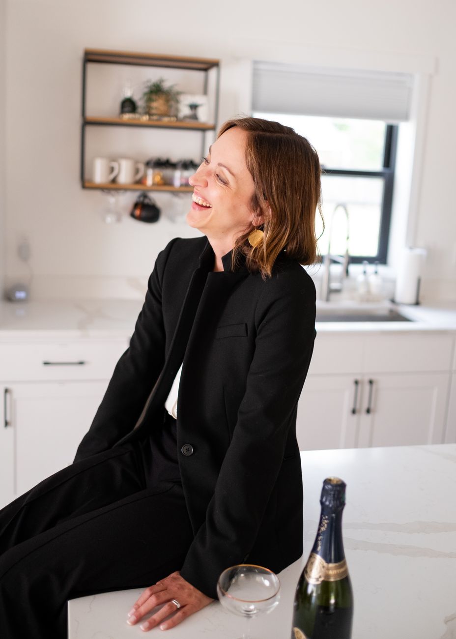 Amy laughing, seated on a kitchen island