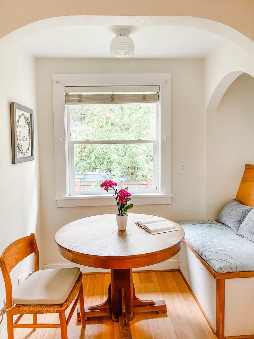 Sunny breakfast nook with a round wood table under an arched doorway